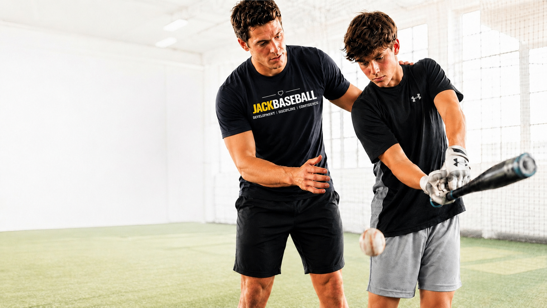 JackBaseball homepage hero showing a professional coach mentoring a young athlete in an indoor batting facility